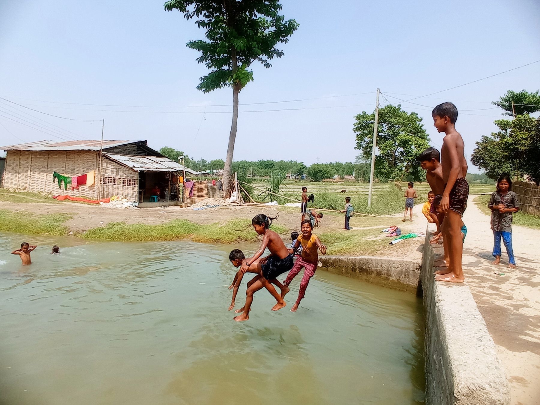 गर्मी छल्न पौडी खेल्दै बालबालिका